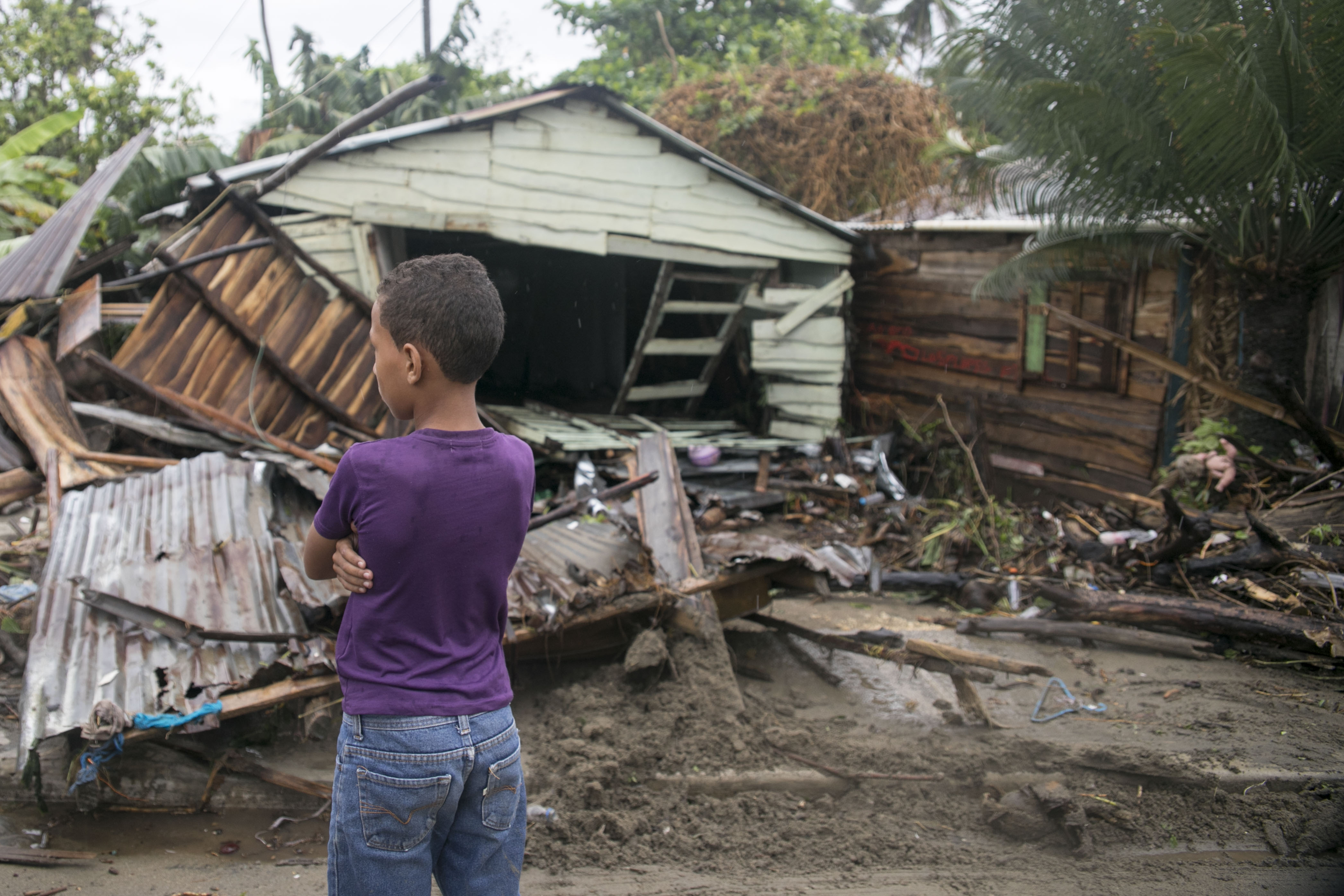 , a boy, 7, stands in front of debris as Hurricane Irma