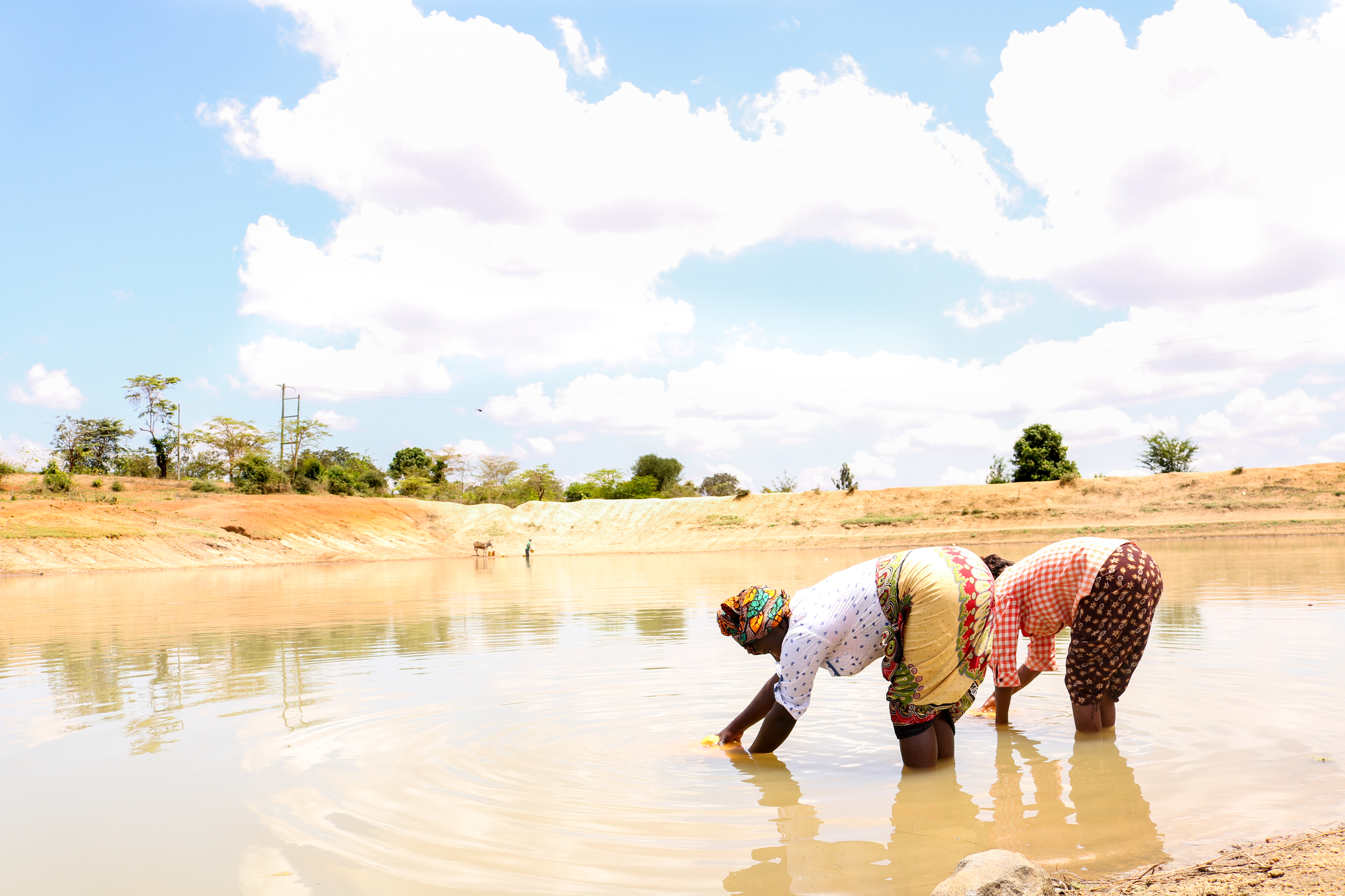 Dorcas Syengo and her neighbour, Jane, fetch water from a dam nearby. Families in this region rely on ground water that has to be purified before it is safe for drinking. They also use it to water their kitchen gardens. 