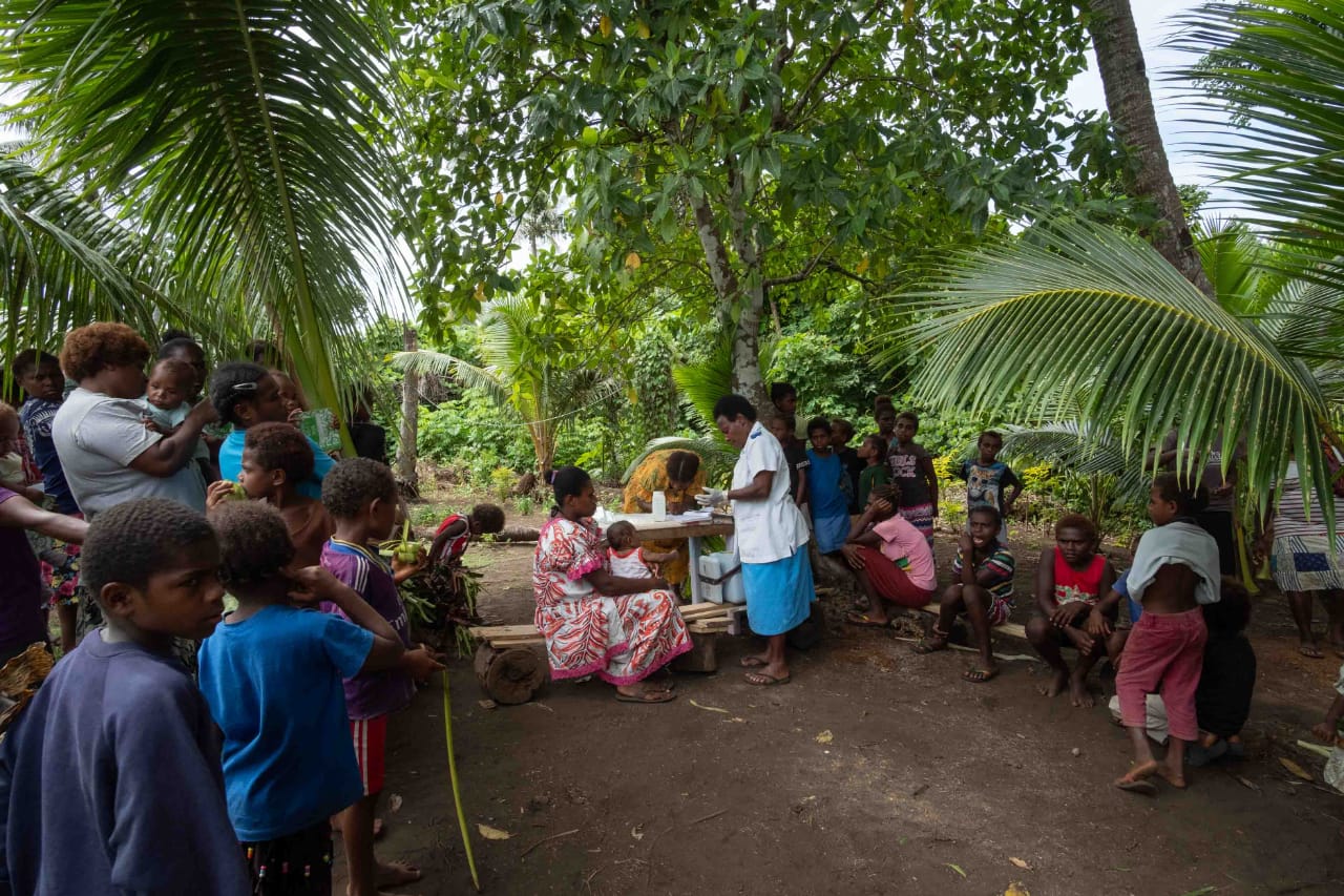 The community gathers around for vaccinations after the drone arrives into Cook’s Bay with the vaccines.