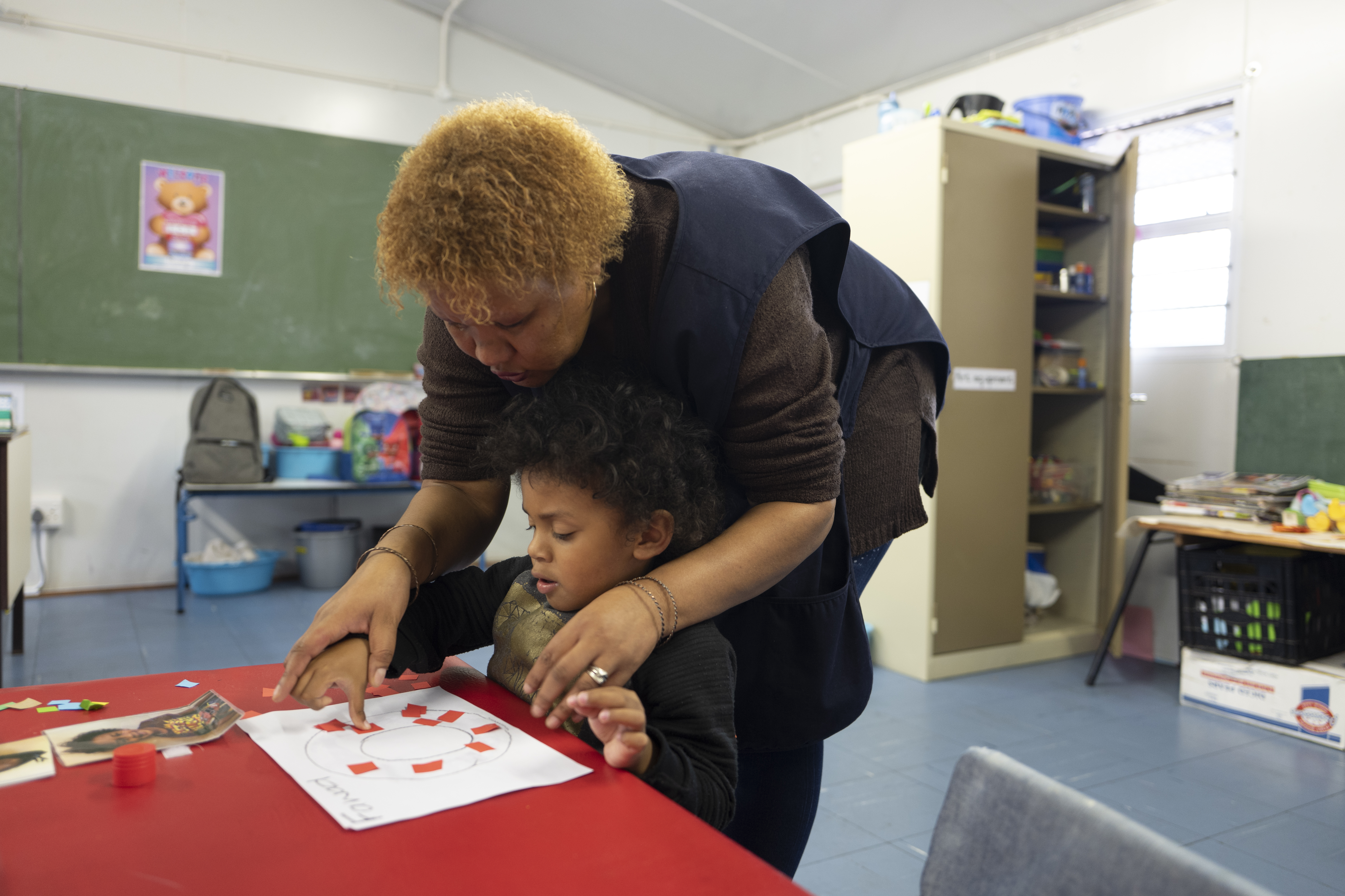 Fawad Abrahams, 4, is helped by a teacher at the Alpha Learners with Autism school, which he has attended since the first of the year, Woodstock, Cape Town, South Africa on 7 May 2019. 