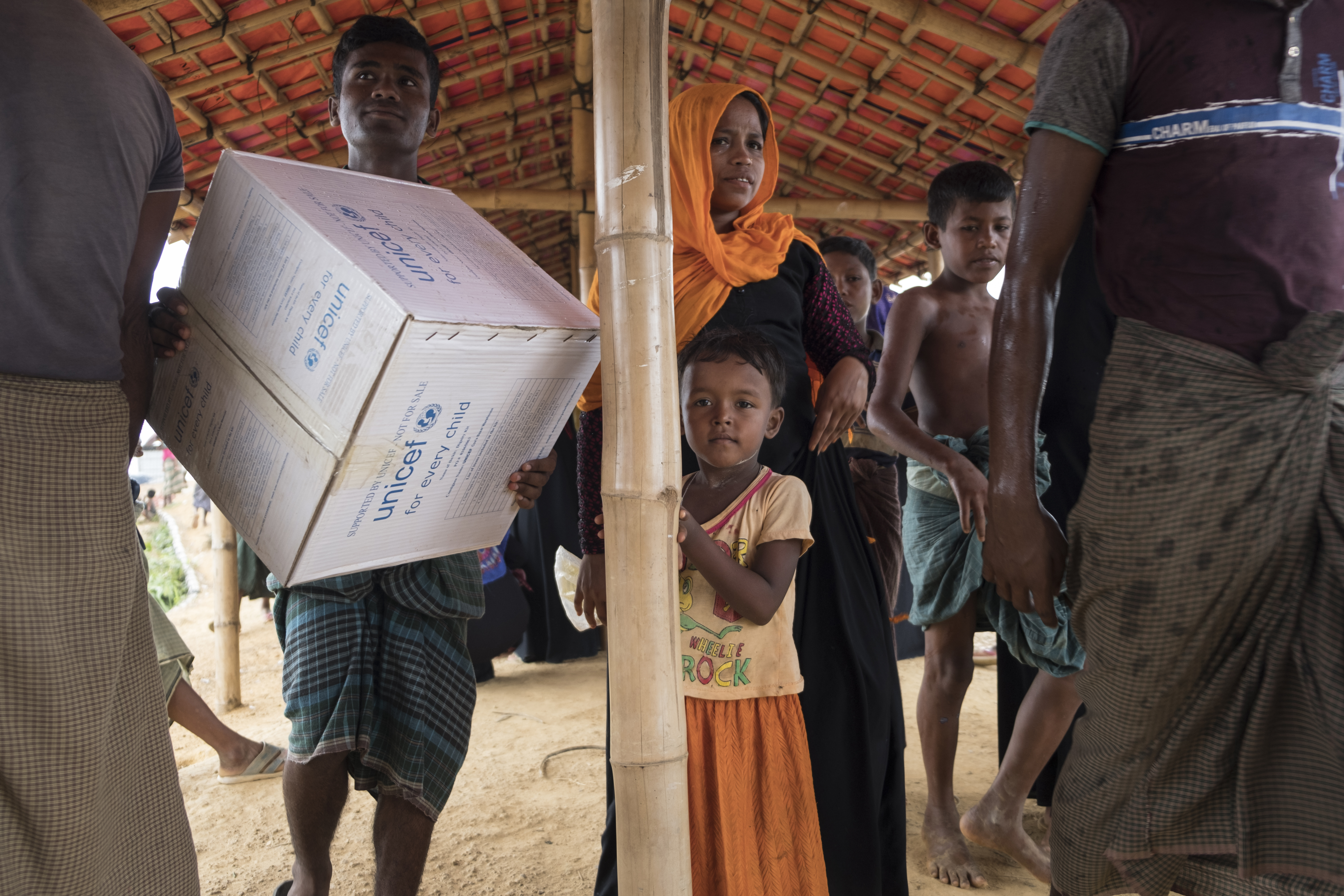 On 26 June 2019, girls and women in the Kutupalong refugee camp in Cox’s Bazar, Bangladesh receive a UNICEF “Dignity Kit,” which contains sanitary napkins, laundry soap, a bucket with a lid, underwear, a scarf, flip flops and a solar torch. 