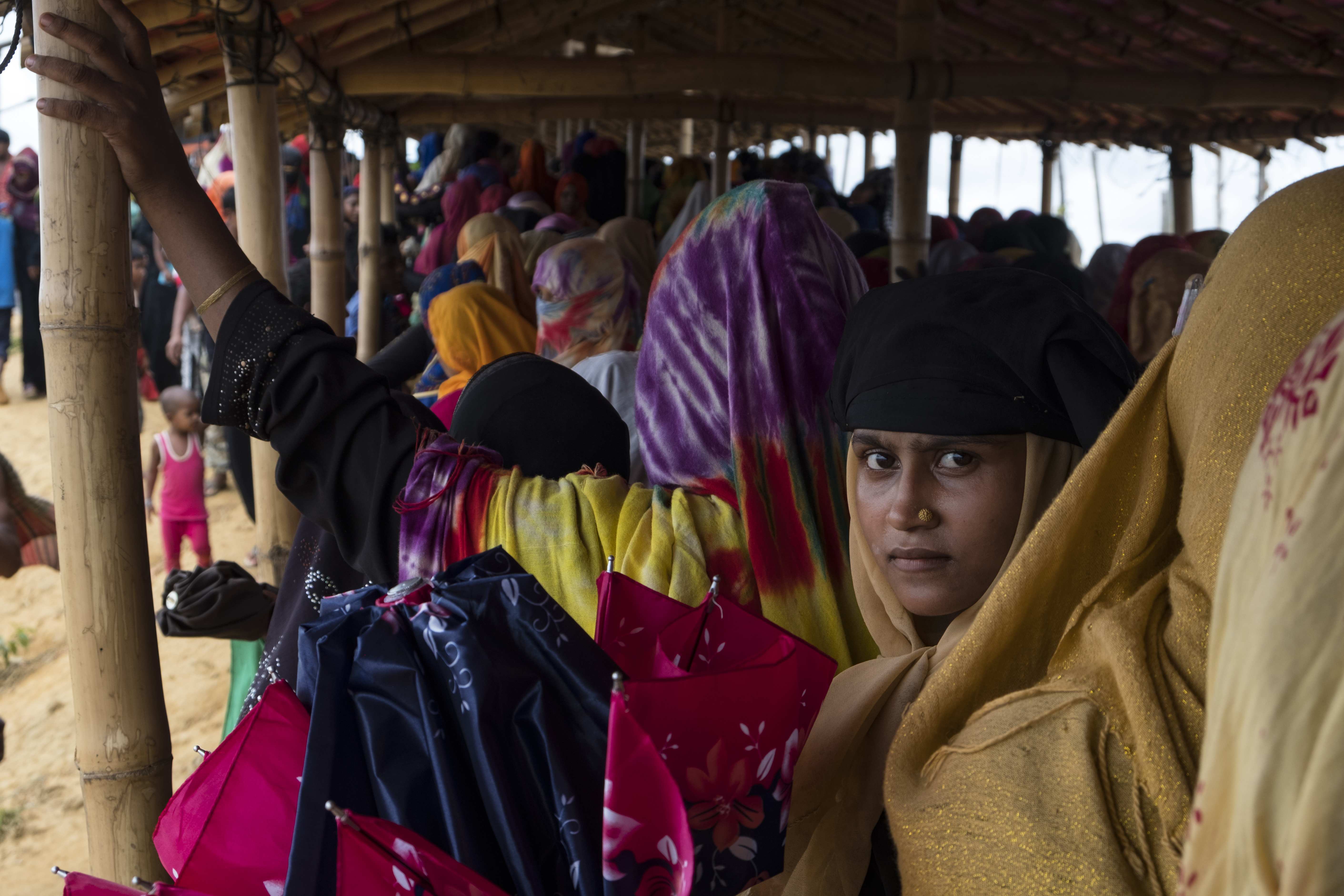 On 26 June 2019, girls and women in the Kutupalong refugee camp in Cox’s Bazar, Bangladesh line up to receive a UNICEF “Dignity Kit,” which contains sanitary napkins, laundry soap, a bucket with a lid, underwear, a scarf, flip flops and a solar torch. 