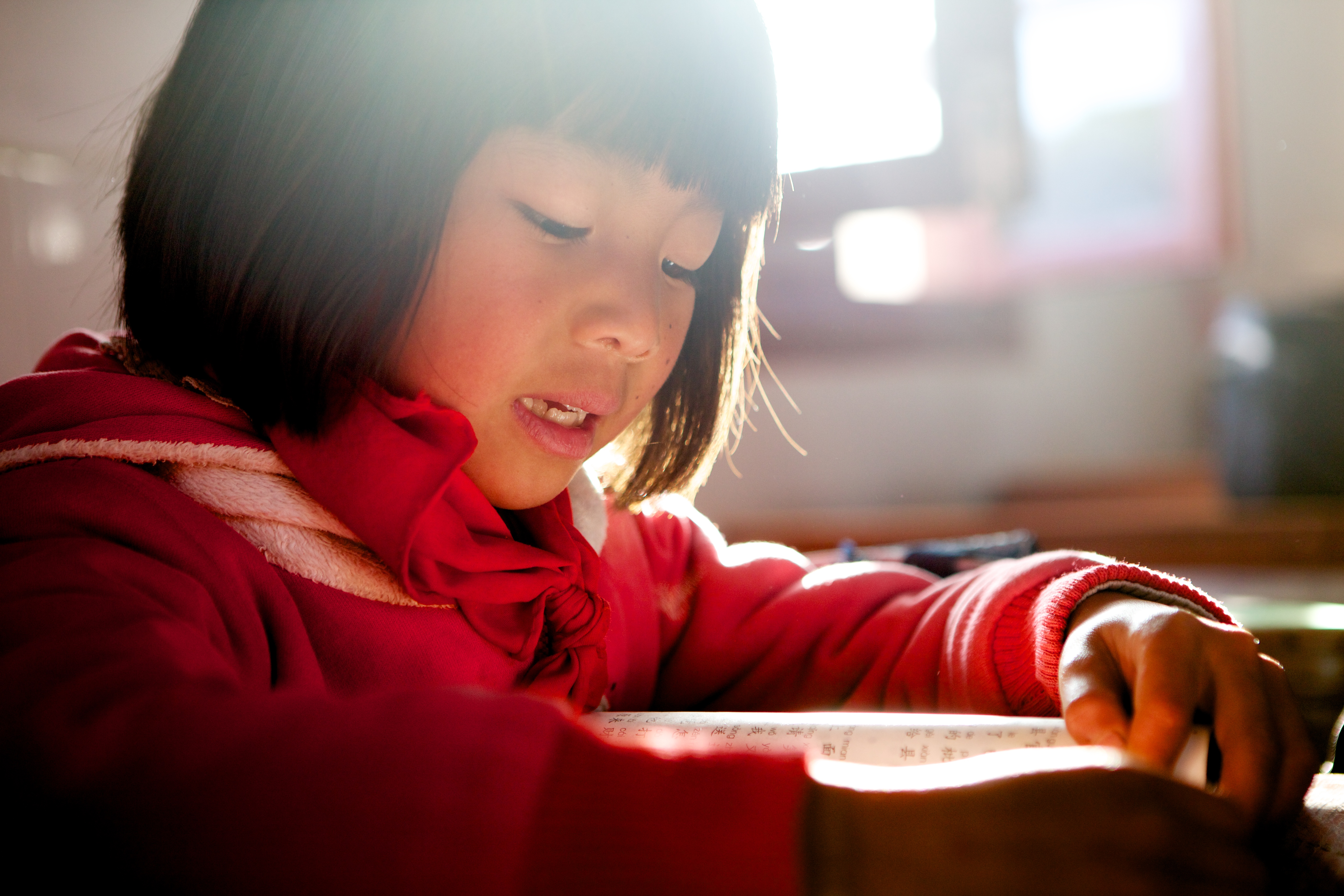 A girl reads a textbook at a school which implements Social Emotional Learning method, in Yunnan Province