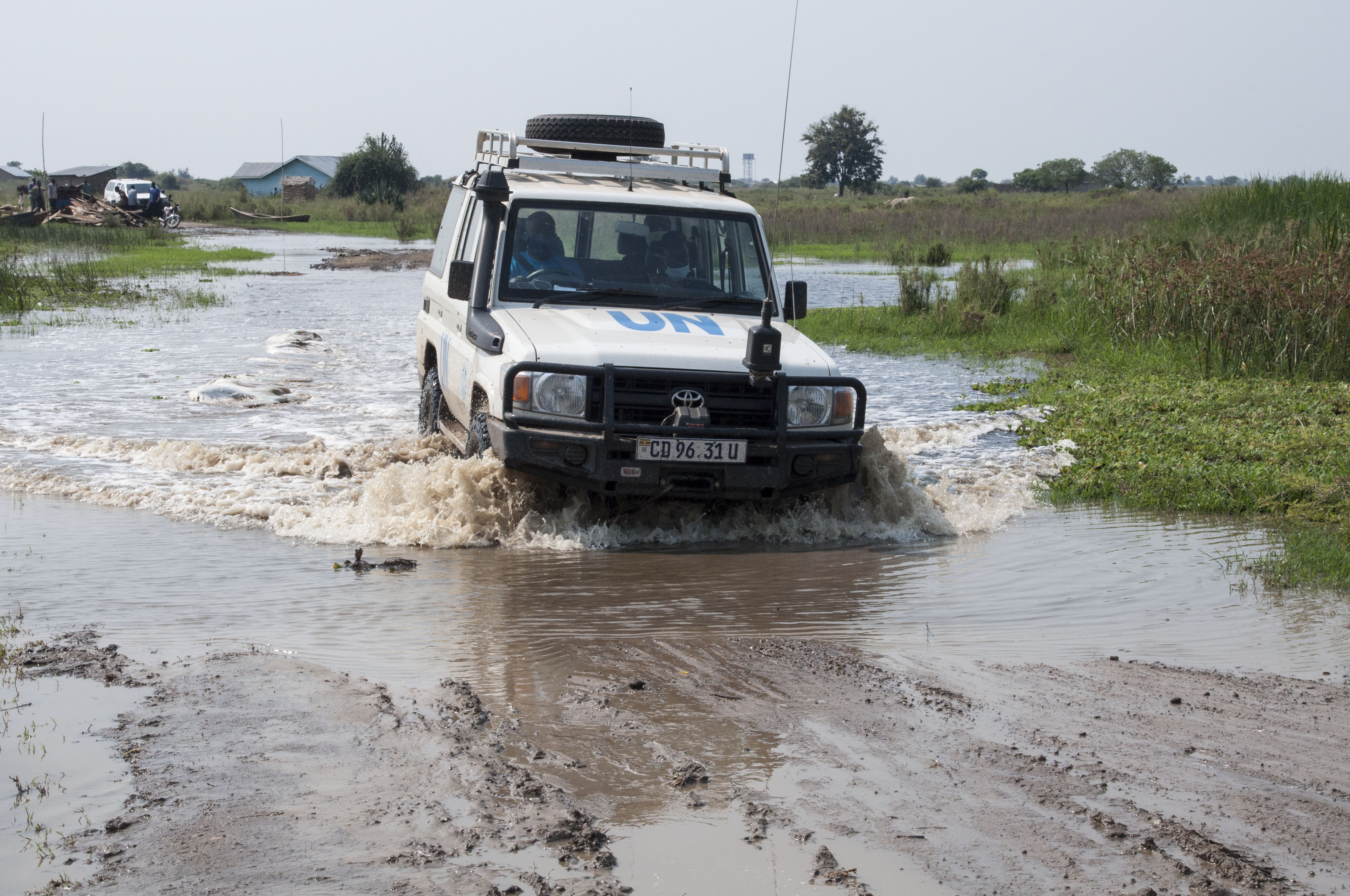 A UNICEF vehicle is driven through a flooded road in Kanara Sub-County in Ntoroko district.