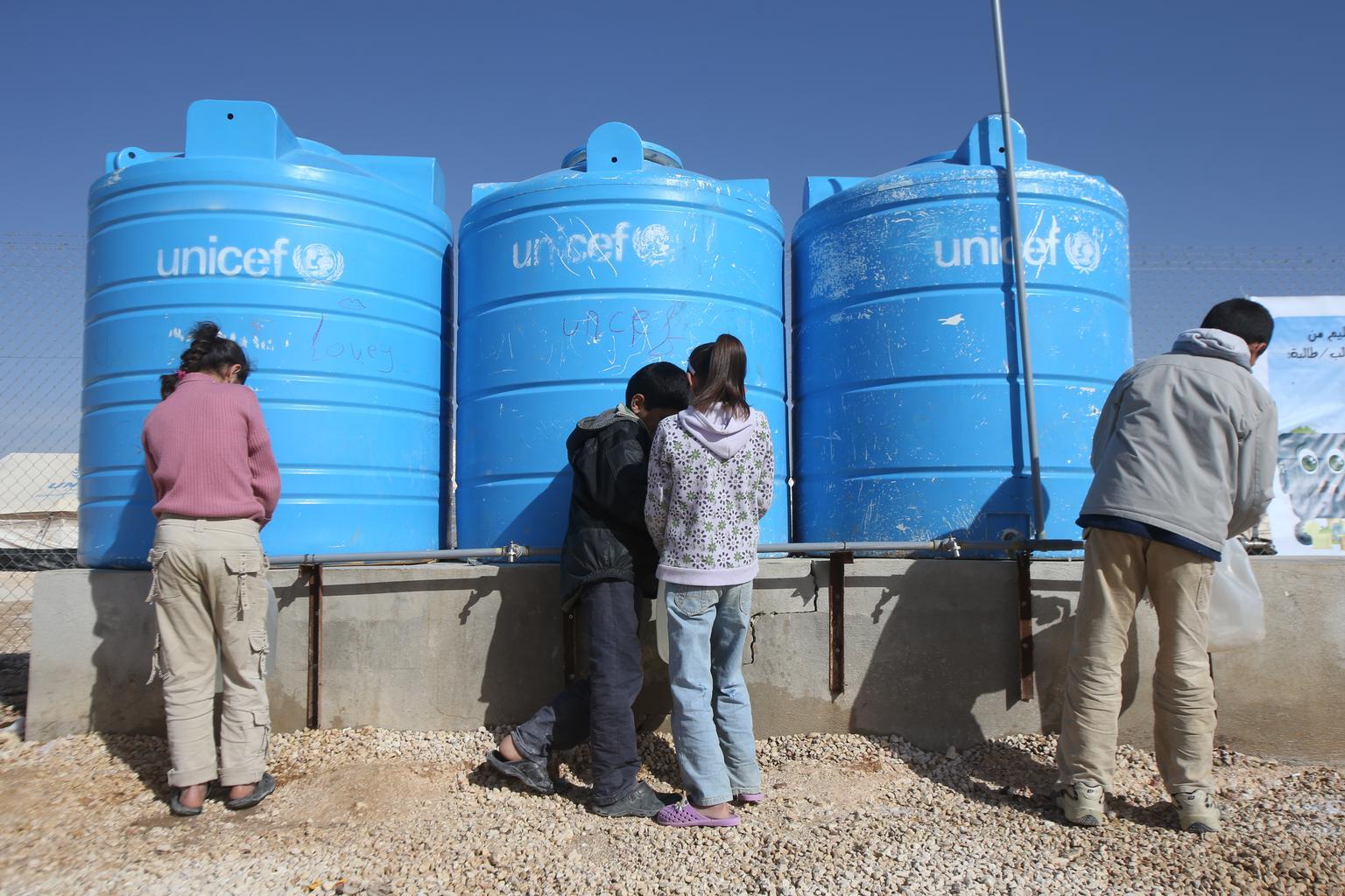 children getting water at a tank 