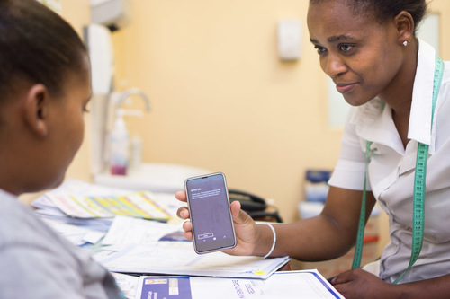A health worker demonstrating a user interface to a patient 