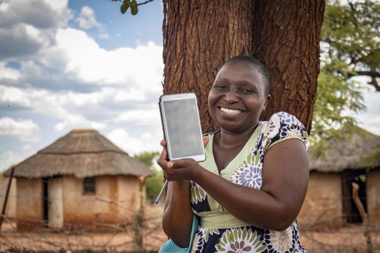 A woman holding up a tablet 
