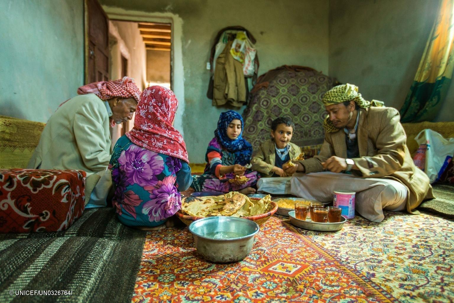 A family from Amran Governorate in Yemen shares lunch. This family used money received through the emergency cash transfer project to purchase food.