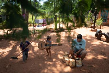 Selva, 2, her brother Amaru, 3, and their father, Rafael Alfonso Araujo, 27, have an impromptu musical concert outside their home in Areguá, Central department, Paraguay on 26 January 2019. 